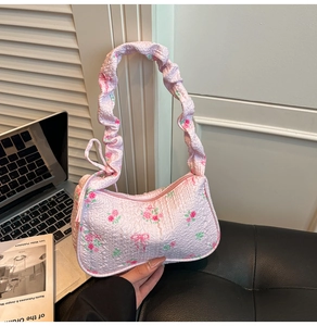 Detailed view of pink floral seersucker underarm bag with ruffled strap and rose pattern
