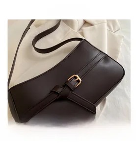 Close-up of deep brown PU leather underarm bag with decorative buckle and stitching