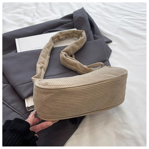 Detail view of beige corduroy shoulder bag with soft padded strap and ribbed texture