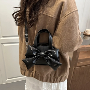 Sac seau noir chic avec nœud et étoiles argentées, porté main ou en bandoulière sac