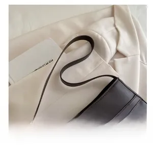 Detail of vintage coffee brown shoulder bag featuring metal buckle and matte leather texture