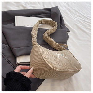 Detail of khaki corduroy shoulder bag with white bow embroidery and pleated strap style