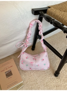 Detail of pink floral shoulder bag with ruffled strap and delicate rose pattern