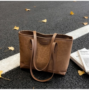 Gros plan du sac cabas léopard avec étiquette en cuir sur fond de feuilles d'automne