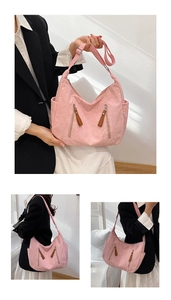 Pink corduroy crossbody crescent bag featuring zipper details and adjustable strap
