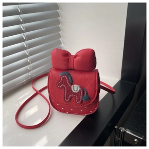 Detail of red crossbody bag with oversized bow and horse embroidery for girls