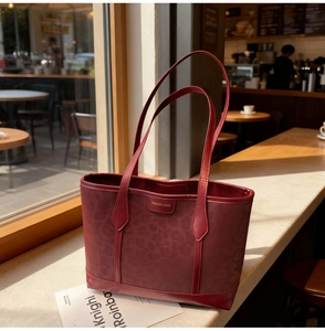 Close-up of burgundy leopard pattern shoulder bag with polished fashion logo detail