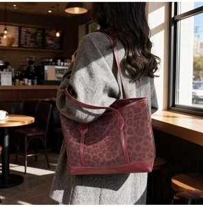 Detail of vintage leopard print tote bag with wine red leather trim and shoulder strap