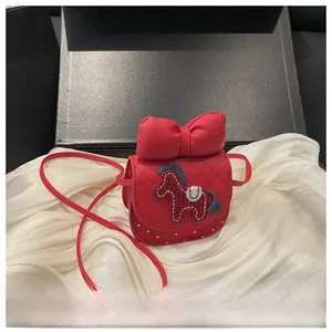 Detail of red quilted leather girls crossbody bag with bow and pony embroidery