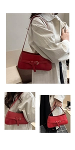 Detail view of a red leather baguette bag with strap buckle and metallic eyelets