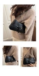 Detail view of black matte PU leather shoulder bag with decorative metallic buckle strap