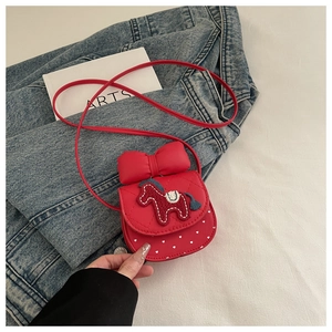 Detail of red girl's crossbody bag with bow, horse embroidery and white heart patterns