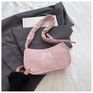 Close-up of pink corduroy shoulder bag featuring white bow embroidery and soft texture