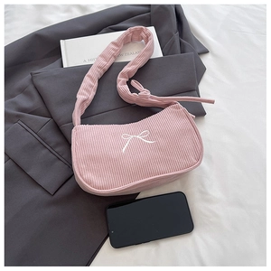 Detail of pink corduroy shoulder bag featuring white bow embroidery and knotted strap design