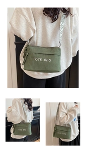 Close-up of green corduroy tote bag featuring TOTE BAG embroidery and ethnic strap