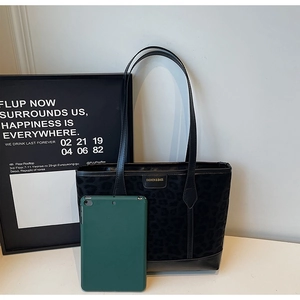 Détail du sac cabas léopard noir montrant sa grande capacité avec une tablette tactile