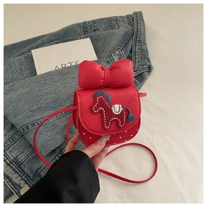 Detail of girls' red quilted crossbody bag with blue horse patch and polka dots