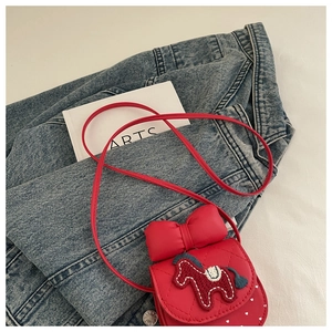 Detail of red girls' crossbody bag featuring bow, pony embroidery, and heart prints