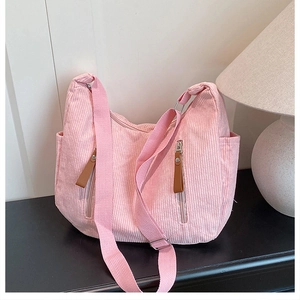 Pink corduroy crossbody bag featuring vertical stripes, dual front zippers and side pockets