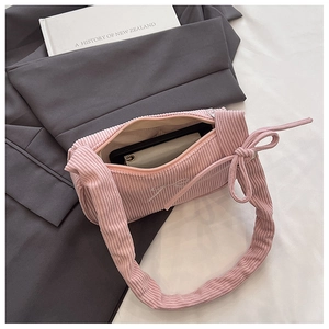 Internal storage detail of pink corduroy baguette bag with bow strap and soft embroidery