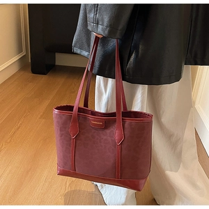 Détail du sac cabas bordeaux en jacquard léopard porté par un mannequin de mode