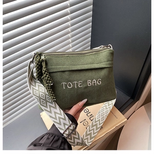 Detail of dark green corduroy tote bag with embroidery and geometric strap