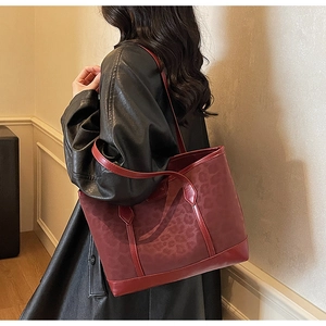 Vue détaillée du sac cabas bordeaux avec motifs léopard élégants et texture mate