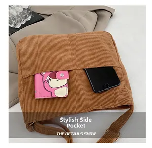 Detail view of corduroy shoulder bag side pocket with phone and wallet inside