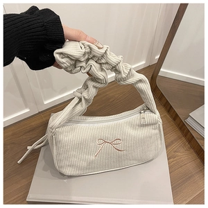 Detail of corduroy underarm bag with pink bow embroidery and pleated handle