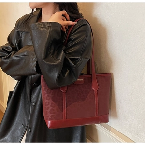 Détail du sac cabas bordeaux à motif léopard avec bandoulière porté par un mannequin