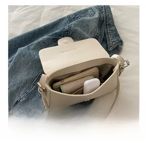 Interior view of off-white leather satchel bag showing storage for daily essentials