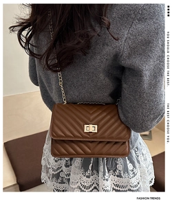 Detailed view of brown quilted leather crossbody bag with gold twist lock on model