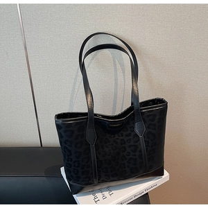Détail du sac cabas patchwork noir à motif léopard sur un livre d'art de style moderne