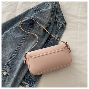 Detail view of pink flap crossbody bag with silver buckle and smooth leather texture