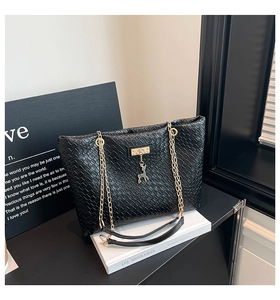 Detailed view of black woven PU leather tote with gold chain strap and deer pendant