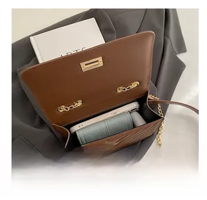 Brown quilted leather shoulder bag interior showing capacity for phone and wallet