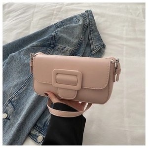 Close-up of pink PU leather flap bag with a square buckle on white fabric background