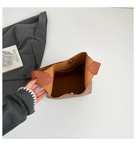 Interior detail of a brown tote bag featuring magnetic closure and inner pocket for storage
