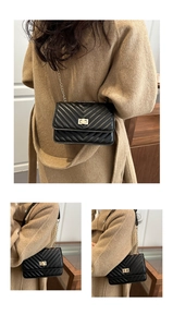 Detail of black quilted crossbody bag with gold twist lock and chain strap on a model