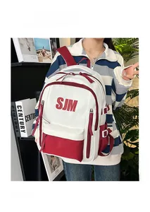 Detail of red and white color-block backpack with SJM logo and dual zipper compartments