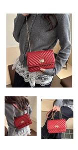 Detail of red V-quilted leather crossbody bag with elegant gold chain and secure flap closure