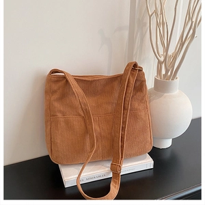 Detail of camel corduroy hobo bag with two front pockets and adjustable strap