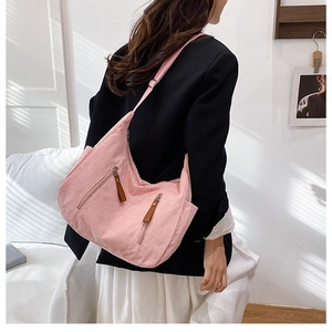 Pink corduroy crossbody bag with double zipper pockets and wide shoulder strap