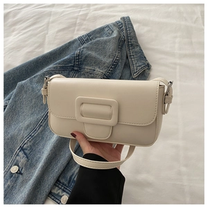 Close-up of minimalist white leather crossbody bag with a large square buckle detail