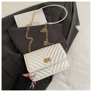 Detail of white V-quilted faux leather crossbody bag with elegant gold twist lock