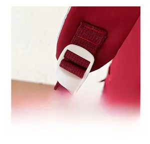 Close-up of red backpack strap with white adjustable plastic buckle and fine weave