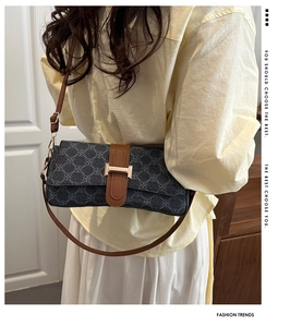 Detail of vintage square bag with floral print, brown leather strap, and gold H-buckle