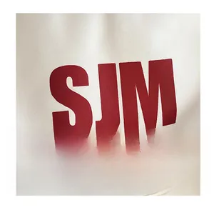 Detail shot of the large red SJM letter print on a durable white canvas backpack