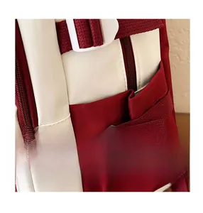 Detail of red and white contrast backpack featuring side reinforcement buckle and nylon fabric