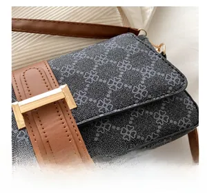 Dettaglio del tessuto jacquard di qualità e finiture in pelle marrone su borsa a tracolla